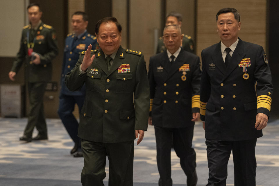 Zhang Youxia, front left, vice chairman of the CPC Central Military Commission, waves as he walks with Hu Zhongming, China's Navy chief on arrival for a group photo before attending the Western Pacific Navy Symposium held in Qingdao in eastern China's Shandong province on Monday, April 22, 2024. Zhang, China's second-ranking military leader under Xi Jinping, took a harsh line on regional territorial disputes on Monday, telling the international naval gathering in northeastern China that the country would strike back with force if its interests came under threat. (AP Photo/Ng Han Guan)
