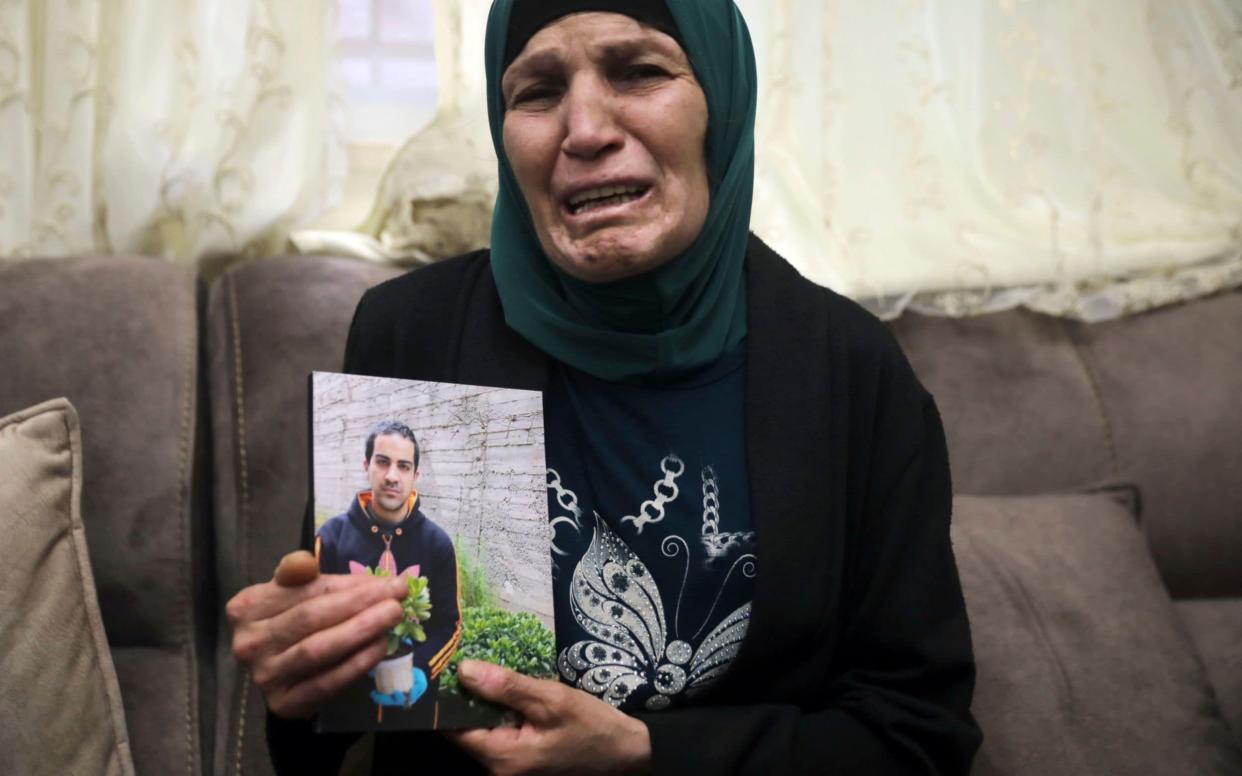 Rana, mother of Iyad Halak, 32, holds his photo at their home  - AP Photo/Mahmoud Illean