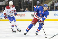 New York Rangers defenseman Ryan Lindgren (55) controls the puck while skating ahead of Montreal Canadiens right wing Josh Anderson (17) during the first period of an NHL hockey game, Sunday, April 7, 2024, at Madison Square Garden in New York. (AP Photo/Mary Altaffer)