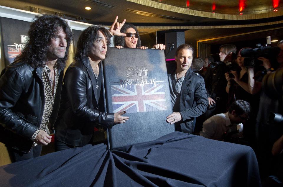 U.S rock band KISS members, from left, Tommy Thayer, Paul Stanley, Gene Simmons and Eric Singer, with their new book 'Monster' which contains photographs of the band's 40 year career live on stage, following a press conference in London, ahead of a concert on July 4 in aid of Help For Heroes. (AP Photo/Joel Ryan)