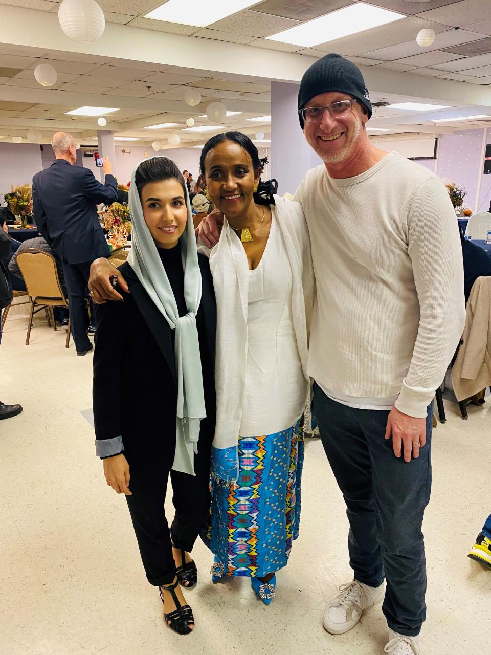 At the Ethiopian Community Development Council's Thanksgiving party on Nov. 20, 2022, in Arlington, Va., from left, refugee case manager Manizha Nuzhat, Executive Director Sarah Zullo and housing coordinator Bob Elston.