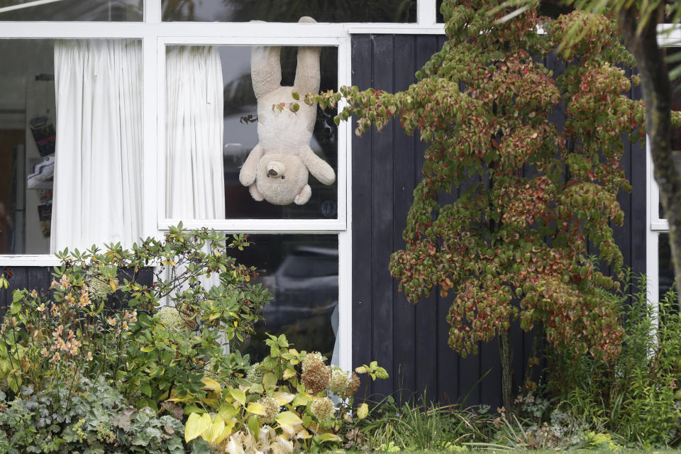 In this Monday, March 30, 2020, photo, a teddy bear hangs upside down in a window of a house in Christchurch, New Zealand. New Zealanders are embracing an international movement in which people are placing teddy bears in their windows during coronavirus lockdowns to brighten the mood and give children a game to play by spotting the bears in their neighborhoods. (AP Photo/Mark Baker)