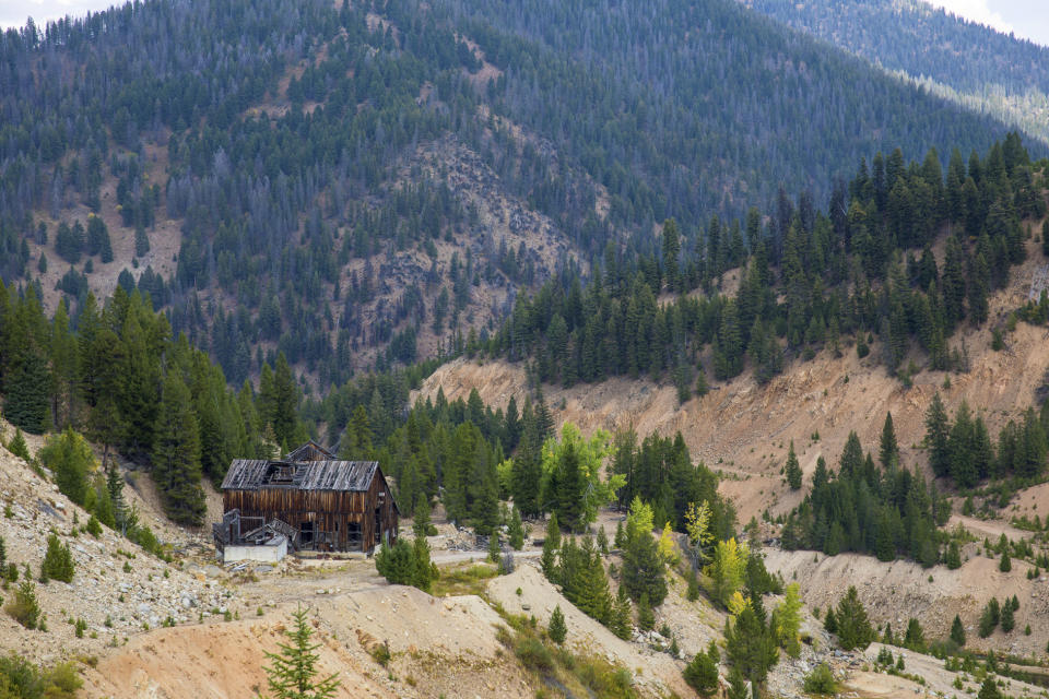 This Sept. 19, 2018 photo shows the last standing building above the Yellow Pine Pit open-pit gold mine in the Stibnite Mining District in central Idaho, where a company hopes to start mining again. Documents show the Trump administration intervening in a U.S. Forest Service decision so that a Canadian company could write a key environmental report on its proposed open-pit gold mines in central Idaho. (Riley Bunch/Idaho Press-Tribune via AP)