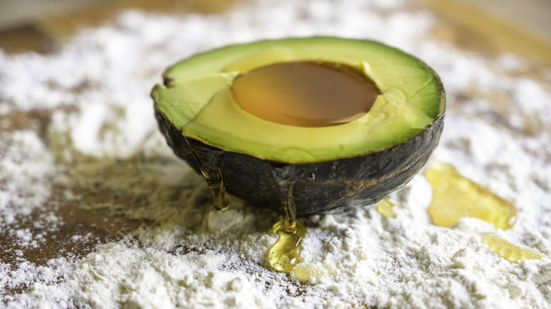 Honey-filled avocado half on floured cutting board