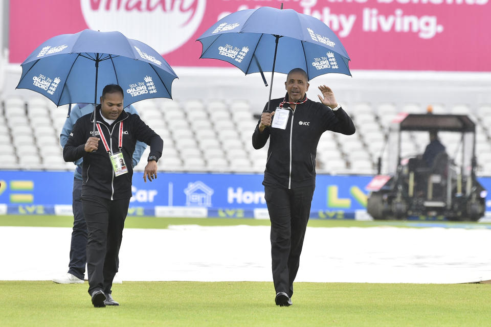 The Umpires Joel Wilson, right, and Nintin Menon inspect the pitch before the start of the fifth day of the fourth Ashes Test match between England and Australia at Old Trafford, Manchester, England, Sunday, July 23, 2023. (AP Photo/Rui Vieira)