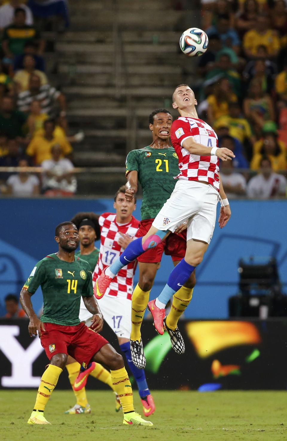 Croatia's Ivan Perisic (R) jumps for the ball with Cameroon's Joel Matip as Cameroon's Aurelien Chedjou (L) watches during their 2014 World Cup Group A soccer match at the Amazonia arena in Manaus June 18, 2014. REUTERS/Yves Herman (BRAZIL - Tags: SOCCER SPORT WORLD CUP TPX IMAGES OF THE DAY)