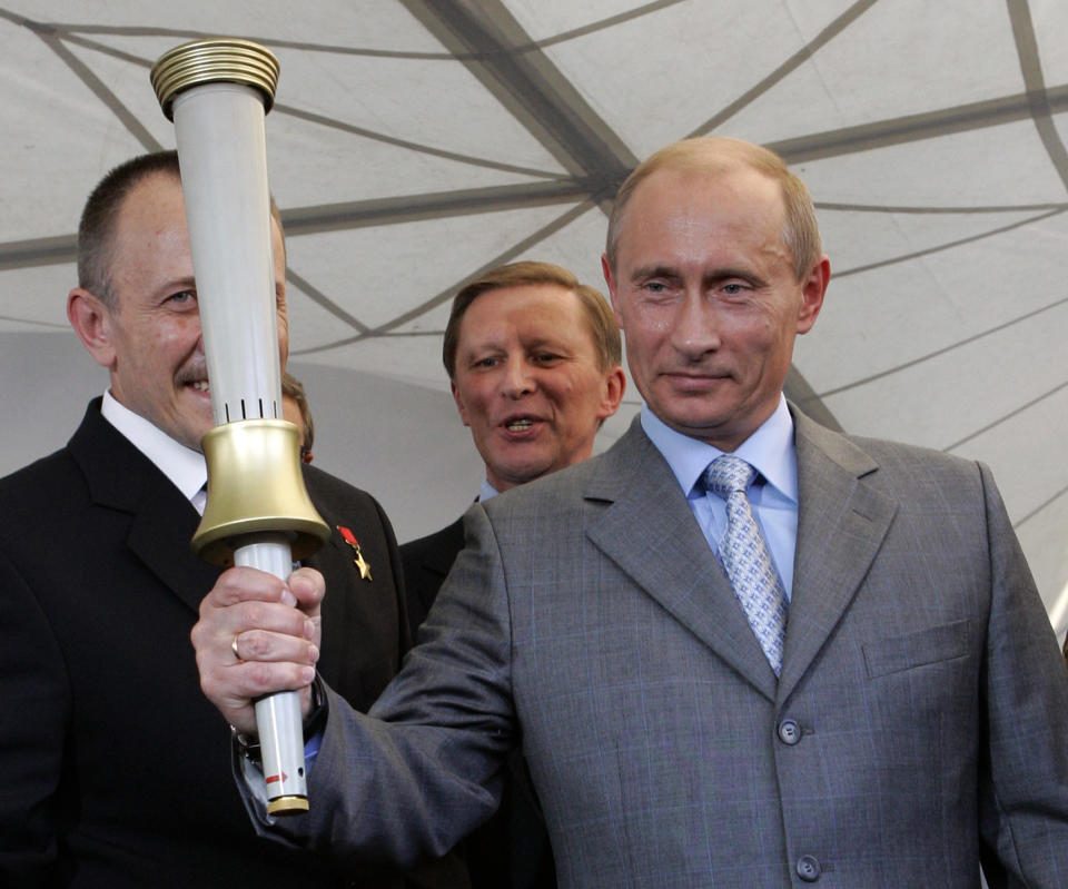 FILE - In this Aug. 11, 2007 file photo, Russian President Vladimir Putin holds one of the torches produced for the 1980 Moscow Olympics during a visit to the Klimov Aircraft Engines Corporation, which made the torches, in St. Petersburg, Russia. Thirty-four years after those Olympics, Putin has similar ambitions: Proving to the world through the 2014 Sochi games that post-Soviet Russia remains a global player, if no longer a superpower. (AP Photo/Alexander Zemlianichenko, File)