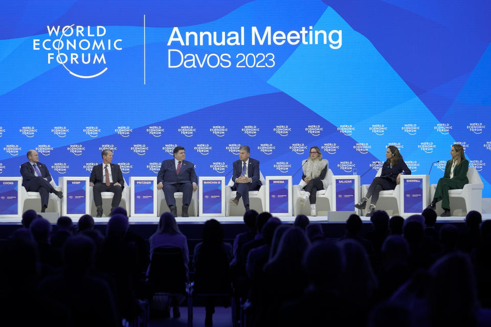 Sen. Chris Coons, Gov. Brian Kemp, Gov. J.B. Pritzker, Sen. Joe Manchin, Sen. Kyrsten Sinema, Rep. Maria Elvira Salazar, and Rep. Mikie Sherrill attend a panel at the World Economic Forum in Davos, Switzerland, Jan. 17, 2023. (AP Photo/Markus Schreiber)