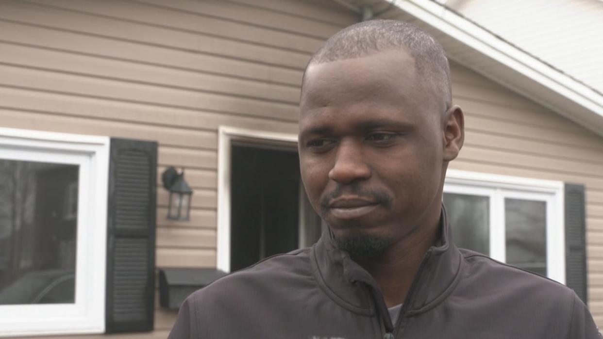 Khalid Yahya stands next to the house he previously lived with his wife and five children. A fire on Friday blazed inside the house, burning many of the family's belonging. The family is currently living in a Housing N.L. unit.  (Mark Cumby/CBC - image credit)