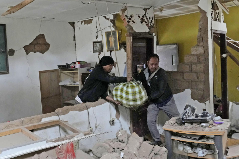 People salvage usable items from their house badly damaged during Monday's earthquake in Cianjur, West Java, Indonesia, Wednesday, Nov. 23, 2022. The earthquake killed a number of people and left hundreds injured and missing on Indonesia's main island. (AP Photo/Tatan Syuflana)