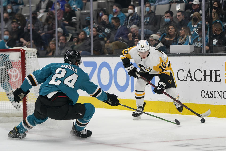 Pittsburgh Penguins left wing Drew O'Connor (10) skates with the puck against San Jose Sharks defenseman Jaycob Megna (24) during the second period of an NHL hockey game in San Jose, Calif., Saturday, Jan. 15, 2022. (AP Photo/Jeff Chiu)