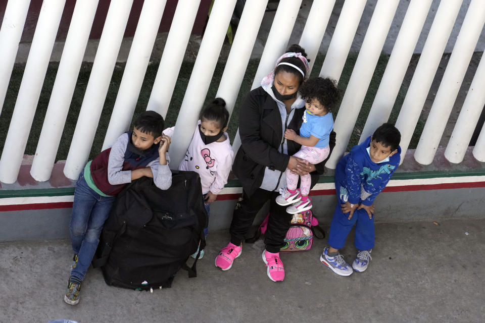 Una familia migrante en un punto de entrada para solicitantes de asilo a Estados Unidos, el miércoles 21 de diciembre de 2022 en Tijuana, México. (AP Foto/Marcio José Sánchez)