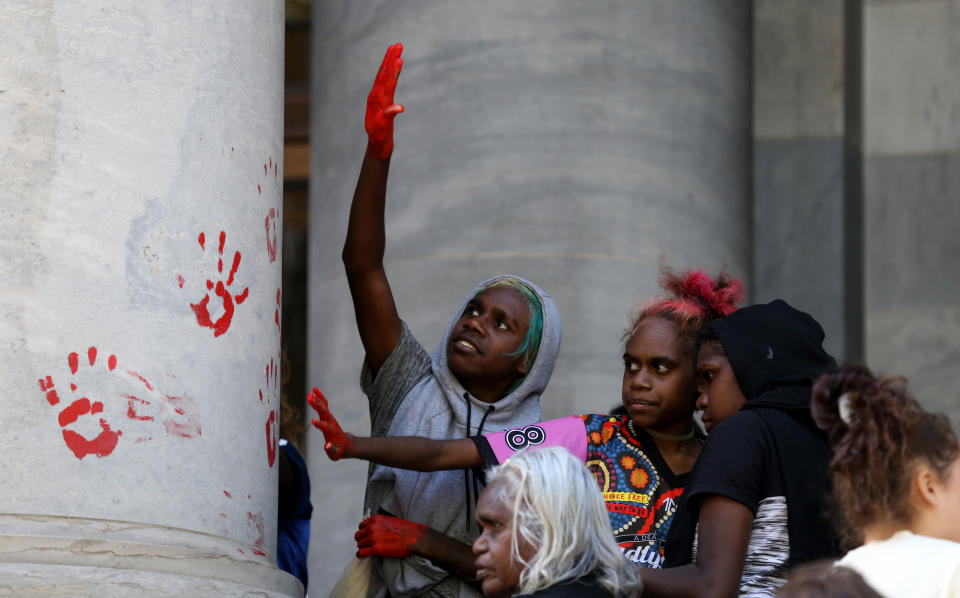 Protestors leave red paint hand prints on a pillar during a protest outside the South Australian Parliament in Adelaide, Wednesday, November 13, 2019. Aboriginal and Torres Strait Islander communities and allies are calling for justice for 19-year-old Warlpiri teenager Kumanjayi Walker, who died after being shot by police on Saturday night in the central desert town of Yuendumu in the Northern Territory. (AAP Image/Kelly Barnes) NO ARCHIVING