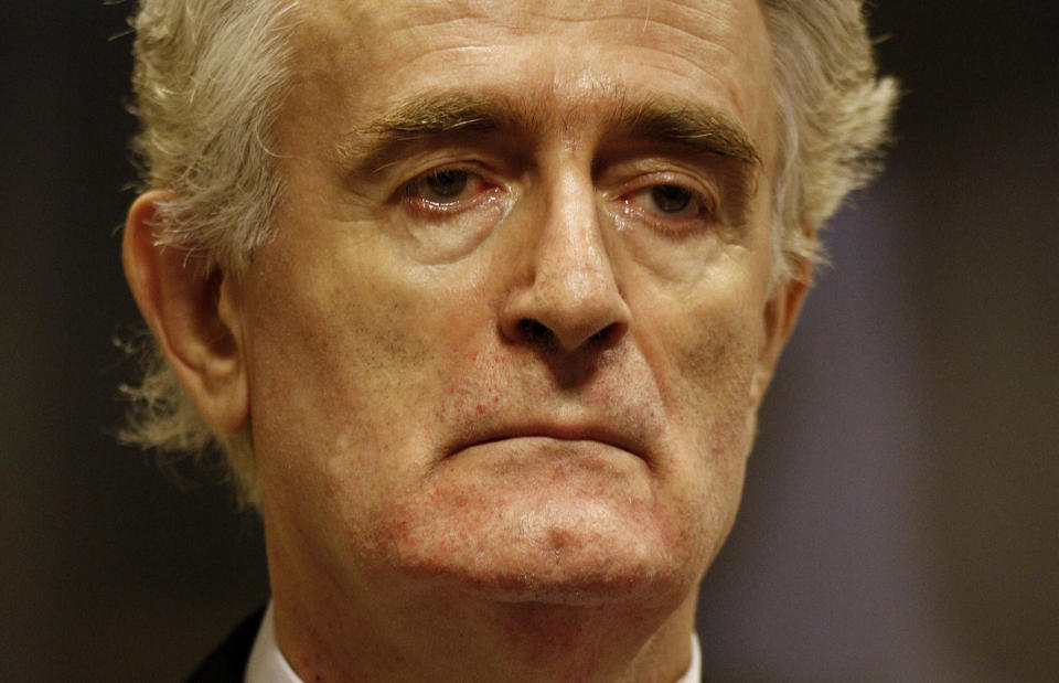 FILE - In this Thursday July 31, 2008 file photo, former Bosnian Serb leader Radovan Karadzic stands in the courtroom during his initial appearance at the U.N.'s Yugoslav war crimes tribunal in The Hague, Netherlands. Nearly a quarter of a century since Bosnia’s devastating war ended, former Bosnian Serb leader Radovan Karadzic is set to hear the final judgment on whether he can be held criminally responsible for unleashing a wave of murder and destruction during Europe’s bloodiest carnage since World War II. United Nations appeals judges on Wednesday March 20, 2019, will decide whether to uphold or overturn Karadzic’s 2016 convictions for genocide, crimes against humanity and war crimes and his 40-year sentence. (Jerry Lampen/Pool via AP, File)