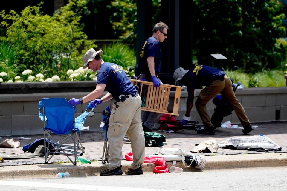 Members of the FBI's evidence response team remove personal belongings one day after a mass shooting in downtown Highland Park, Illinois.
