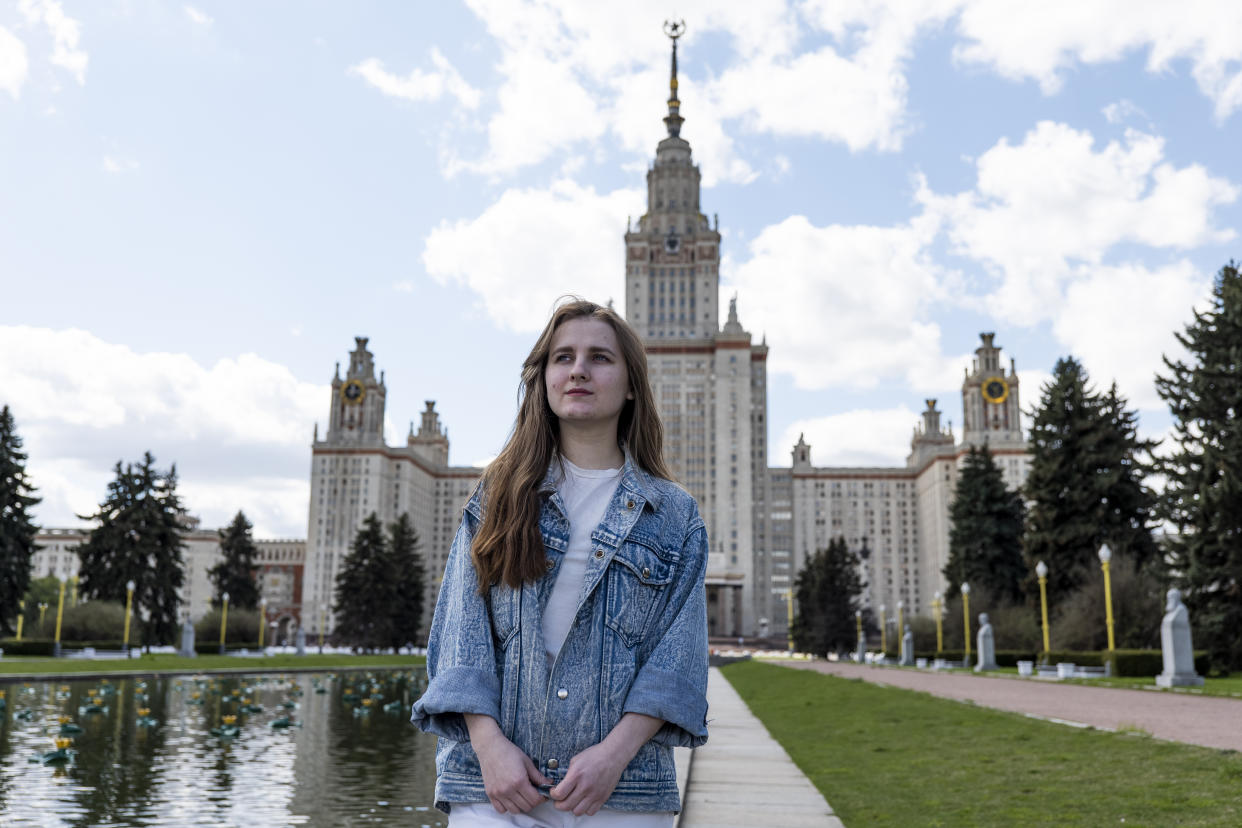 Yulia Kukula stands in front of the Moscow State University during her interview with the Associated Press in Moscow, Russia, Friday, May 7, 2021. Kukula, a university student who was accepted for a PhD program in sustainable energy at Arizona State University, may have found a laborious and costly away around the problem of getting her visa to go the university. (AP Photo/Daniel Kozin)