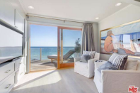 <p>This sitting room shows the wood floors and ocean views that that are found throughout the home. (Trulia.com) </p>