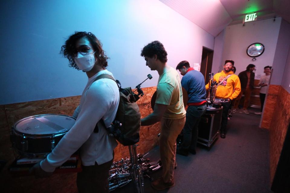 Musicians line a hallway buying musical equipment