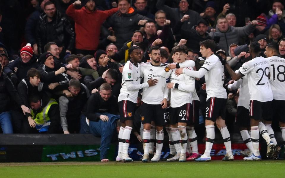  Bruno Fernandes of Manchester United celebrates with teammates after scoring the team's third goal as fans knock over the advertising boards during the Carabao Cup Semi Final 1st Leg match between Nottingham Forest and Manchester United at City Ground on January 25, 2023 in Nottingham, England - Laurence Griffiths/Getty Images