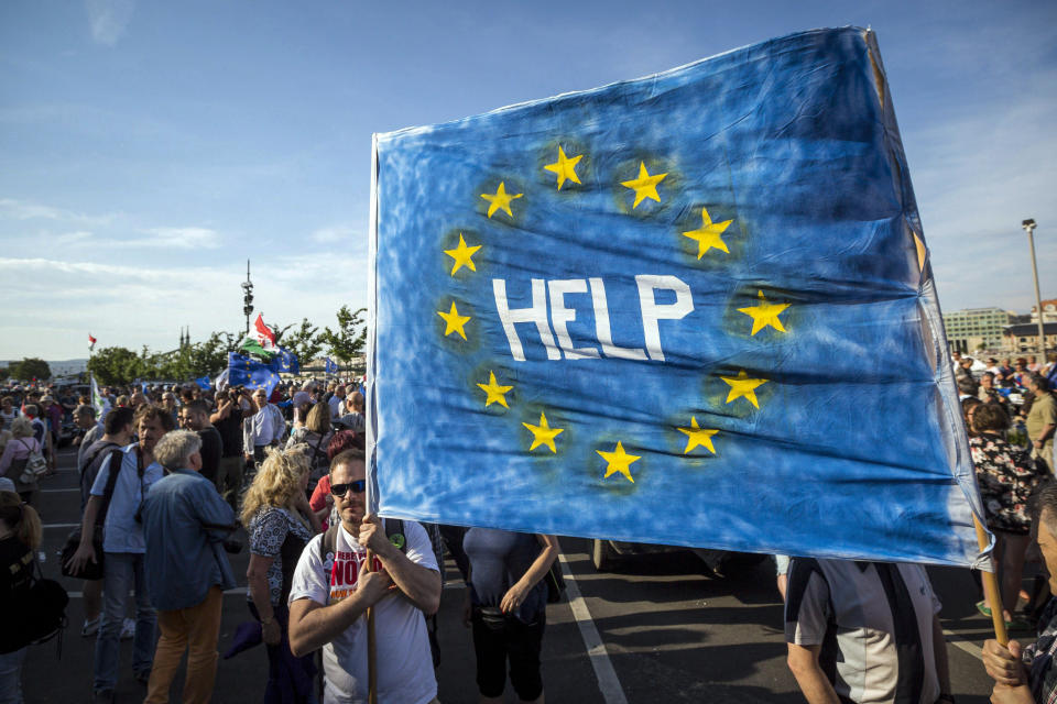 FILE - In this May 21, 2017 file photo, supporters of Hungary's political opposition display a banner during an anti-government protest, at Budapest University of Technology and Economics in Budapest, Hungary. When Hungary and Poland joined the European Union in 2004, after decades of Communist domination, they thirsted for Western democratic standards and prosperity. Yet 17 years later, as the EU ramps up efforts to rein in democratic backsliding in both countries, some of the governing right-wing populists in Hungary and Poland are comparing the bloc to their former Soviet oppressors — and flirting with the prospect of exiting the bloc. (Balazs Mohai/MTI via AP, File)