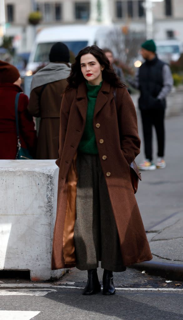 Zoey Deutch is Winter-Ready in Long Brown Coat and Sharp Boots for