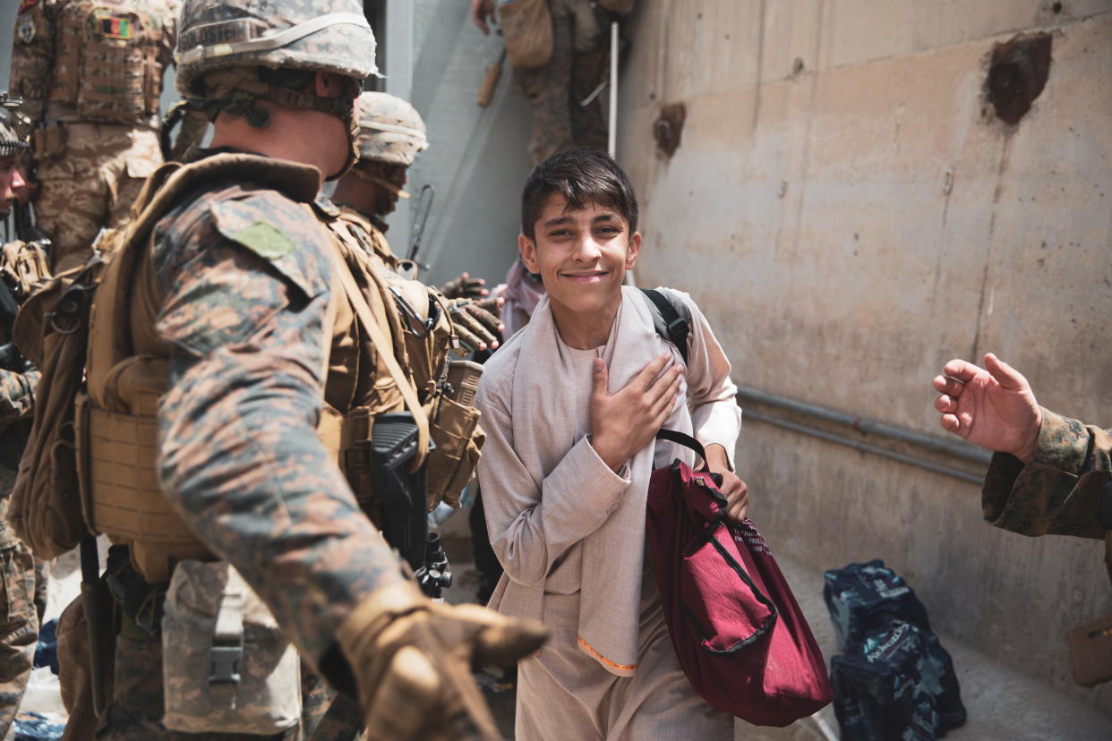 A boy is processed through an Evacuee Control Checkpoint (ECC) during an evacuation at Hamid Karzai International Airport, Kabul, Afghanistan August 18, 2021. (U.S. Marine Corps/Staff Sgt. Victor Mancilla/Handout via Reuters)