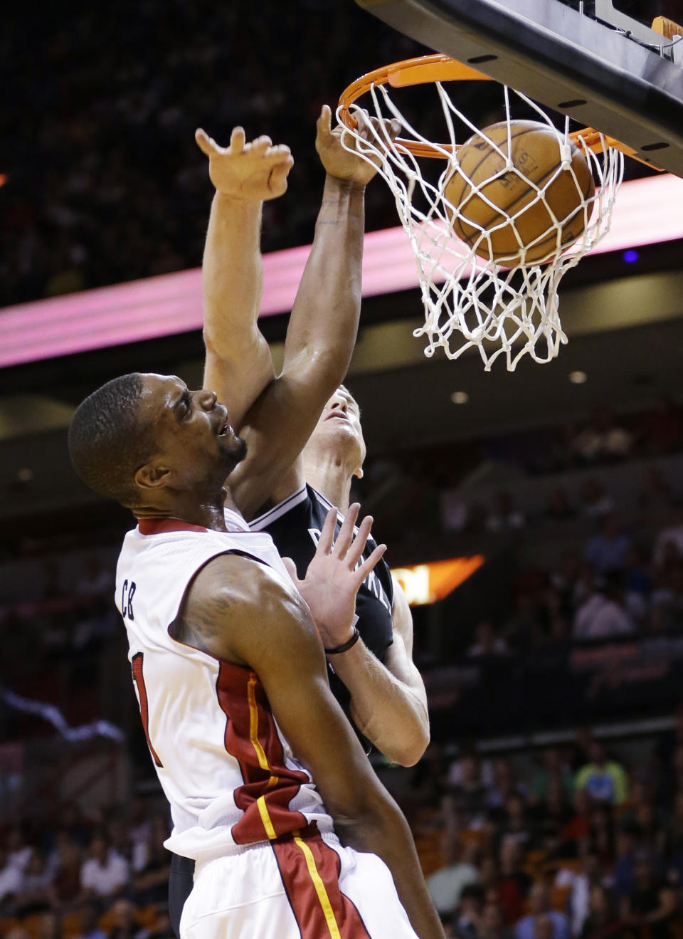 Miami Heat center Chris Bosh, foreground dunks the ball against Brooklyn Nets forward Mason Plumlee during the first half of an NBA basketball game, Wednesday, March 12, 2014, in Miami. (AP Photo/Wilfredo Lee)