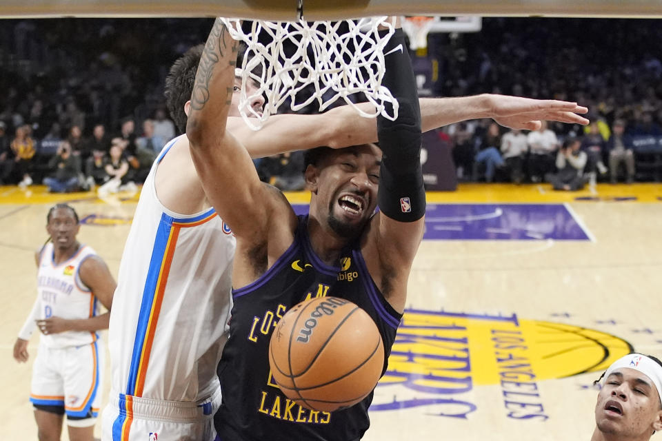 Los Angeles Lakers forward Christian Wood, right, dunks as Oklahoma City Thunder forward Chet Holmgren defends during the first half of an NBA basketball game Monday, Jan. 15, 2024, in Los Angeles. (AP Photo/Mark J. Terrill)