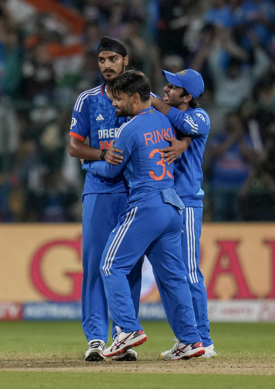 India’s Arshdeep Singh, left, celebrates with teammates Rinku Singh, center, and Ravi Bishnoi after their win the fifth T20 cricket match against Australia in Bengaluru, India, Sunday, Dec. 3, 2023. (AP Photo/Aijaz Rahi)