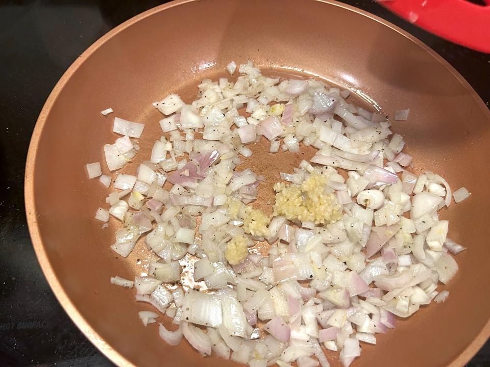 Adding onions and garlic to pan for Gordon Ramsay's 10-minute scampi