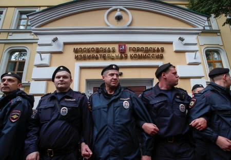 Police officers block protesters during a rally in Moscow