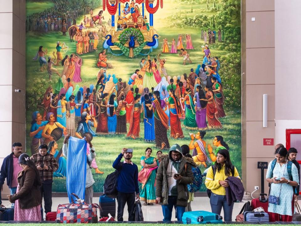 Ayodhya's new airport, pictured on Jan. 17 at two weeks old, features motifs from the Indian epic Ramayana based on the life of Ram. In the background is a depiction of the scene when Ram returns with Sita to Ayodhya after a 14-year exile. In the foreground, a more mundane reality plays out.<span class="copyright">Mahesh Shantaram for TIME</span>