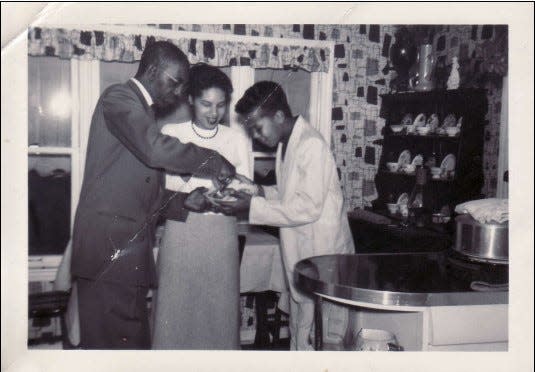 Sandra McWorter Marsh, center, along with her brother, Abdul Alkalimat, at left, and their uncle, James Yates, taste one of Marsh's dishes at Yates' home in Kansas City, Mo., in a photo taken by their aunt Ellen in the late 1950s, when the siblings were in high school. Marsh, now 82, donated her collection of more than 1,700 cookbooks to the culinary program at Chicago's Kennedy-King College in early 2023.