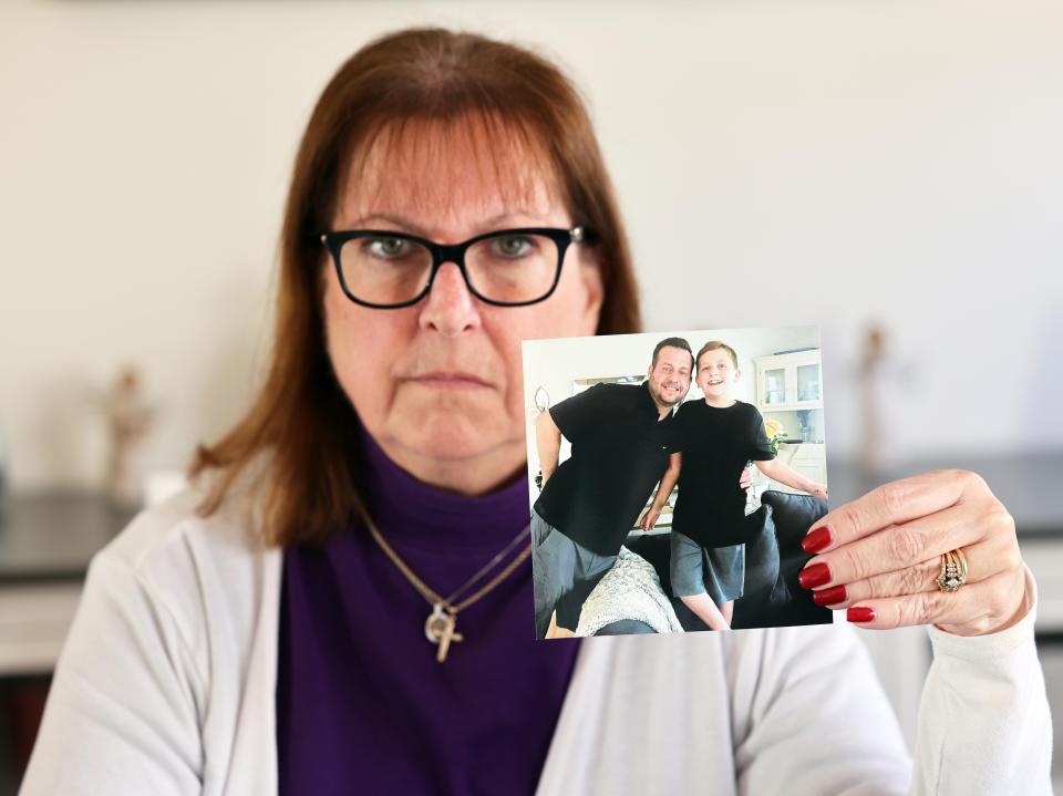 Cheryl Juaire holds a photograph of her late son Sean Merill with his son, Jonathon, at her Marlboro home on Wednesday, March 16, 2022. Sean Merrill, who previously worked at Teen Challenge, a recovery organization in Brockton, died of an opioid overdose in 2021.