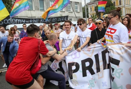 Participants of the Equality March, organized by the LGBT community, scuffle with a man attempting to break their march in Kiev