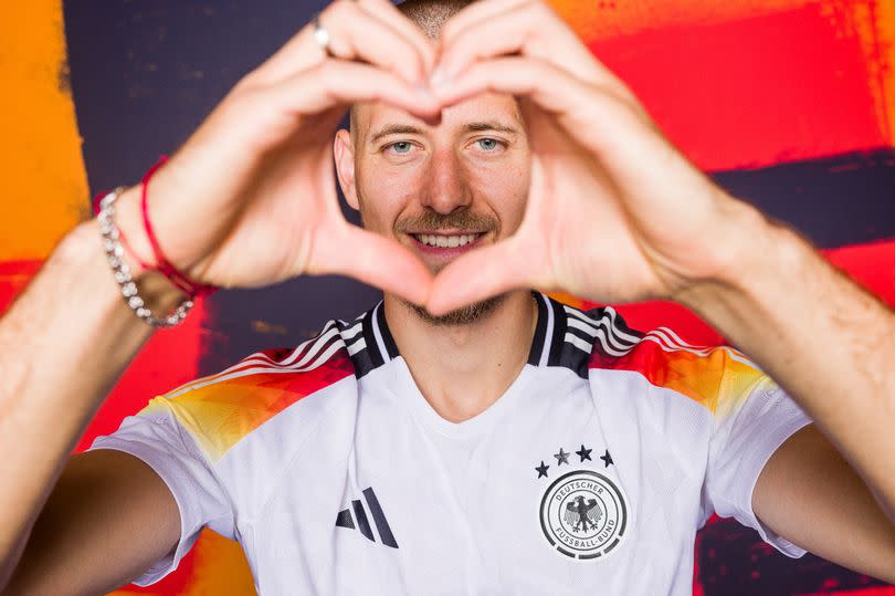 Waldemar Anton makes a heart gesture with his hands during a photoshoot ahead of Euro 2024