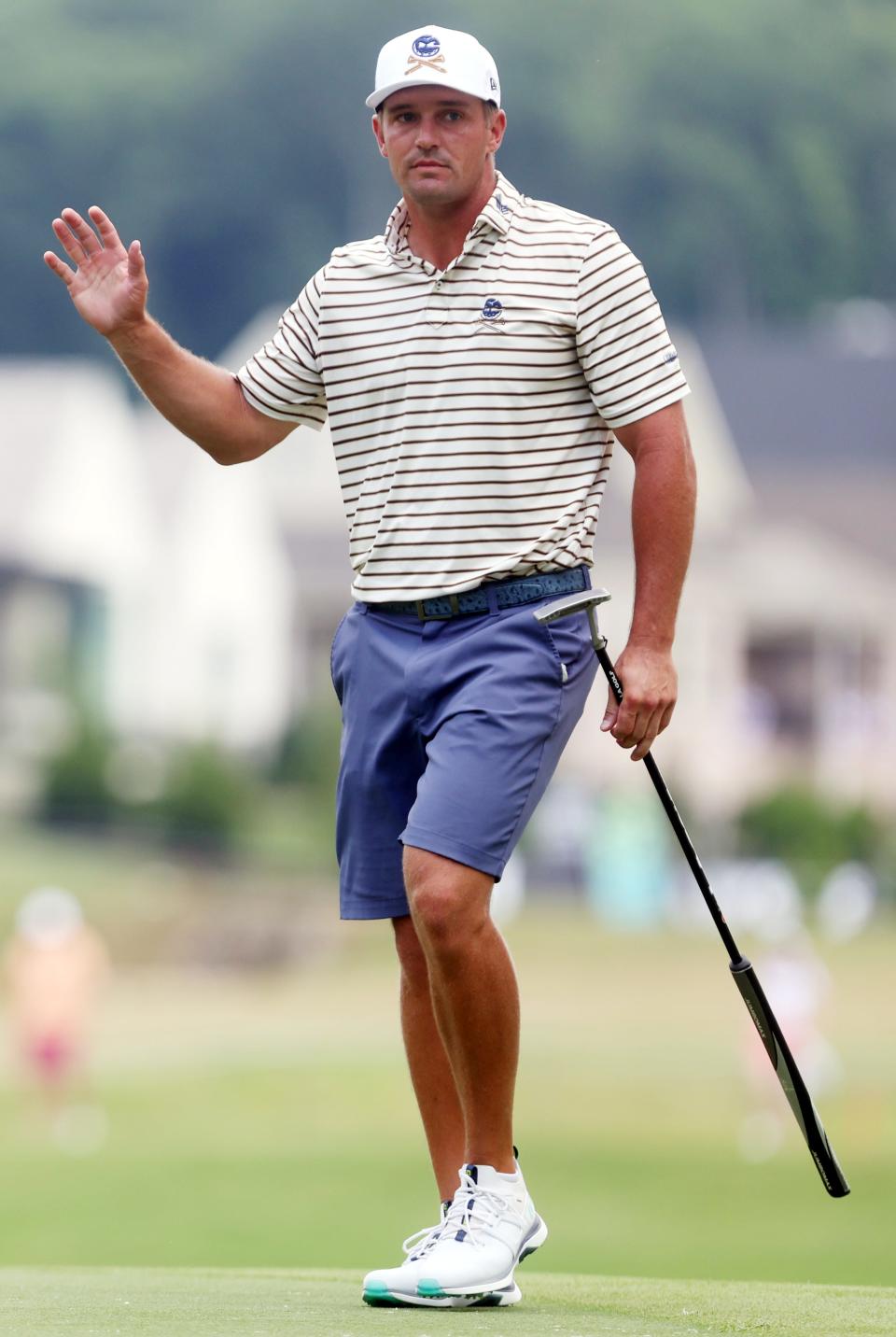 Bryson DeChambeau of Crushers GC waves to cheering fans after making a putt during round 2 of the LIV Golf Tournament at The Grove in College Grove Saturday, June 22, 2024.