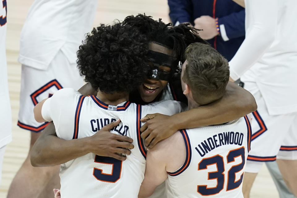 Illinois's Ayo Dosunmu hugs Andre Curbelo (5) and Tyler Underwood (32) after Illinois defeated Ohio State in overtime of an NCAA college basketball championship game at the Big Ten Conference tournament, Sunday, March 14, 2021, in Indianapolis. Illinois won in overtime. (AP Photo/Darron Cummings)