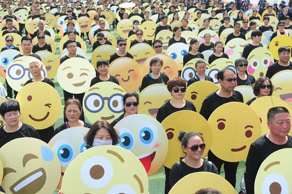 People dress as emoji faces to set an Guinness World Record on a school playground on May 27, 2018 in Fuyang, Anhui Province of China. Guinness World Record of most people dressed up as emoji faces was achieved by 932 participants on Sunday in Fuyang. (Photo by VCG/VCG via Getty Images)