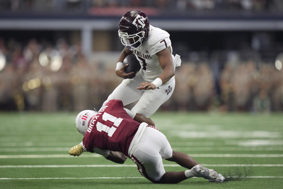 Texas A&M wide receiver Moose Muhammad III (7) tries to pick up extra yards after a catch against Arkansas defender Jaylon Braxton (11) during the first half of an NCAA college football game in Dallas, Saturday, Sept. 30, 2023. (AP Photo/LM Otero)