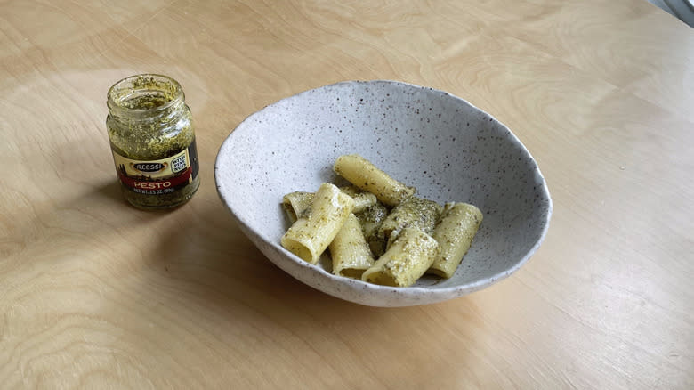 pesto jar next to pasta bowl 