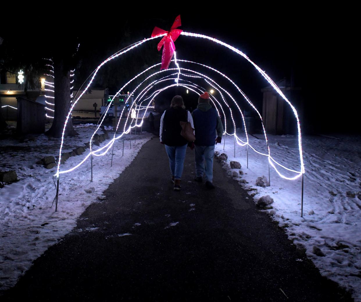 Heather and Marty Briggs of Perry Township take a stroll through a light display at Stark Parks' Deck the Hollow at Quail Hollow Park in Lake Township.