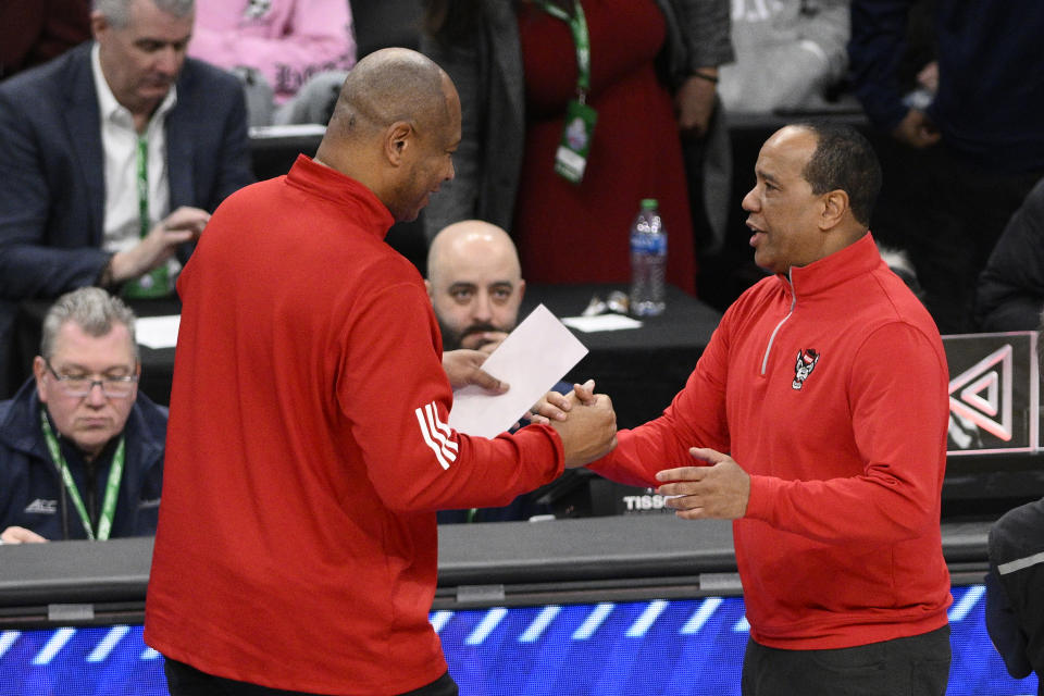Louisville head coach Kenny Payne, left, and North Carolina State head coach Kevin Keatts, right, at the end of the second half of the Atlantic Coast Conference NCAA college basketball tournament Tuesday, March 12, 2024, in Washington. North Carolina State won 94-85 to advance. (AP Photo/Nick Wass)