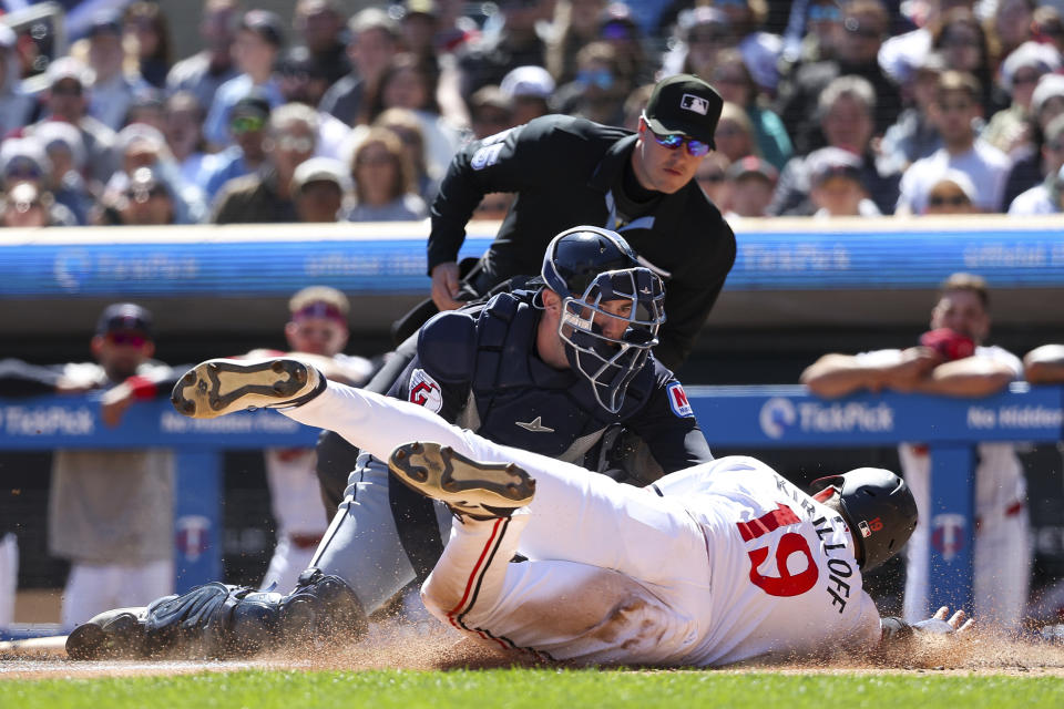 Cleveland Guardians catcher David Fry, center, tags out Minnesota Twins' Alex Kirilloff (19) at home plate during the first inning of a baseball game, Saturday, April 6, 2024, in Minneapolis. (AP Photo/Matt Krohn)