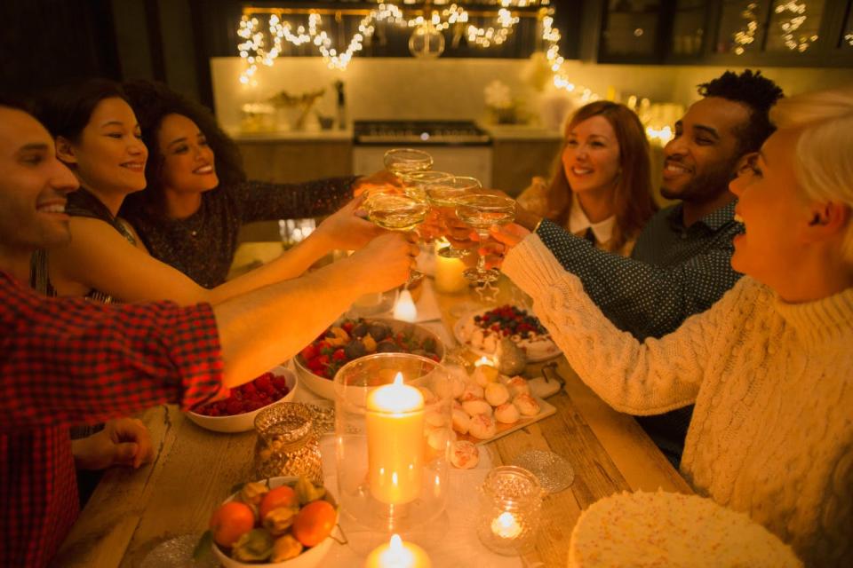 A group of friends toasts by candlelight