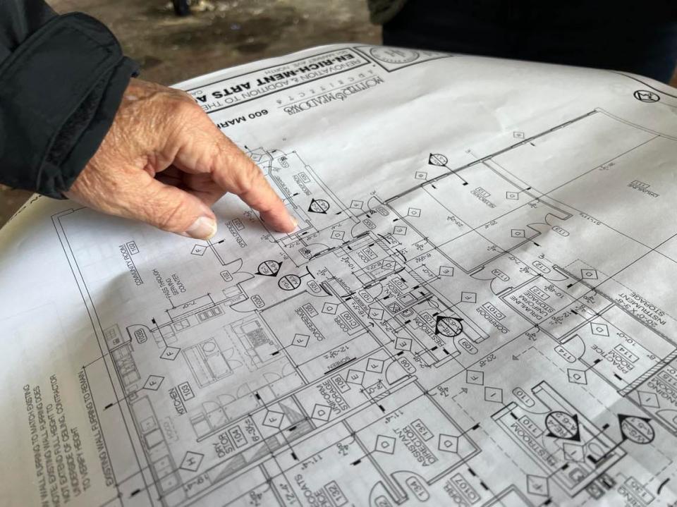 Ted Swaldo points at blueprint plans for renovations to the former Ziegler Tire building in downtown Canton. The building will become the permanent home of EN-RICH-MENT Fine Arts Academy.