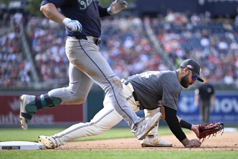 Washington Nationals first baseman Joey Gallo, right, hangs onto a wide throw to put out Seattle Mariners Ty France, left, during the seventh inning of a baseball game, Saturday, May 25, 2024, in Washington. (AP Photo/John McDonnell)