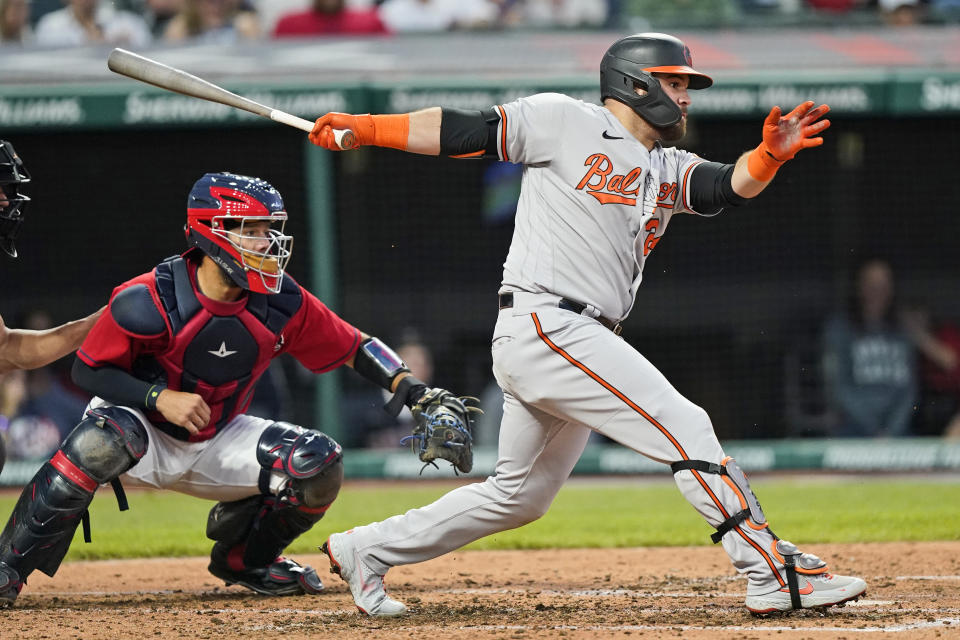 Baltimore Orioles' DJ Stewart, right, hits against the Cleveland Indians in the fourth inning of a baseball game, Monday, June 14, 2021, in Cleveland. Stewart was out at first base. Trey Mancini scored on the play. Indians catcher Rene Rivera watches. (AP Photo/Tony Dejak)