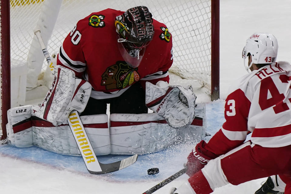 Chicago Blackhawks goalie Malcolm Subban, left, makes a save on a shot by Detroit Red Wings left wing Darren Helm, right, during the second period of an NHL hockey game in Chicago, Saturday, Feb. 27, 2021. (AP Photo/Nam Y. Huh)