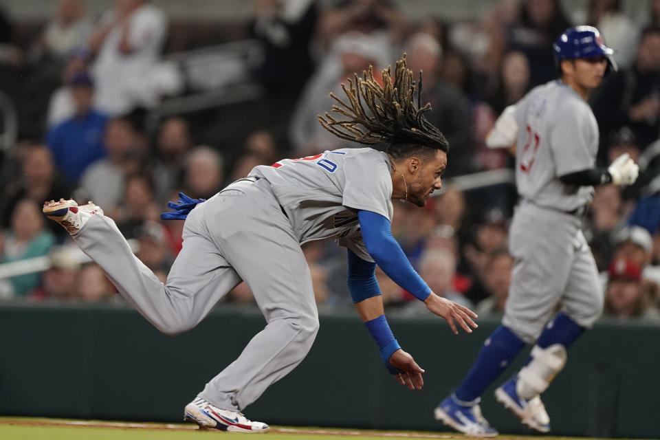Chicago Cubs' Michael Hermosillo (32) dives into first base before being tagged out by Atlanta Braves first baseman Matt Olson (28) in the eighth inning of a baseball game, Tuesday, April 26, 2022, in Atlanta. (AP Photo/Brynn Anderson)